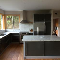 Muebles de cocina en gris con acentos en plata; encimera de piedra natural